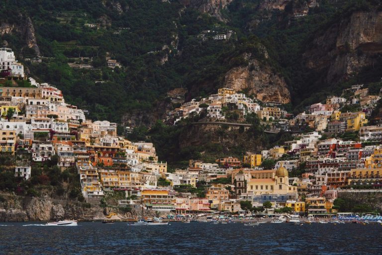 Kleurige huizen en gebouwen tegen een bergwand aan de Amalfikust, Italië.